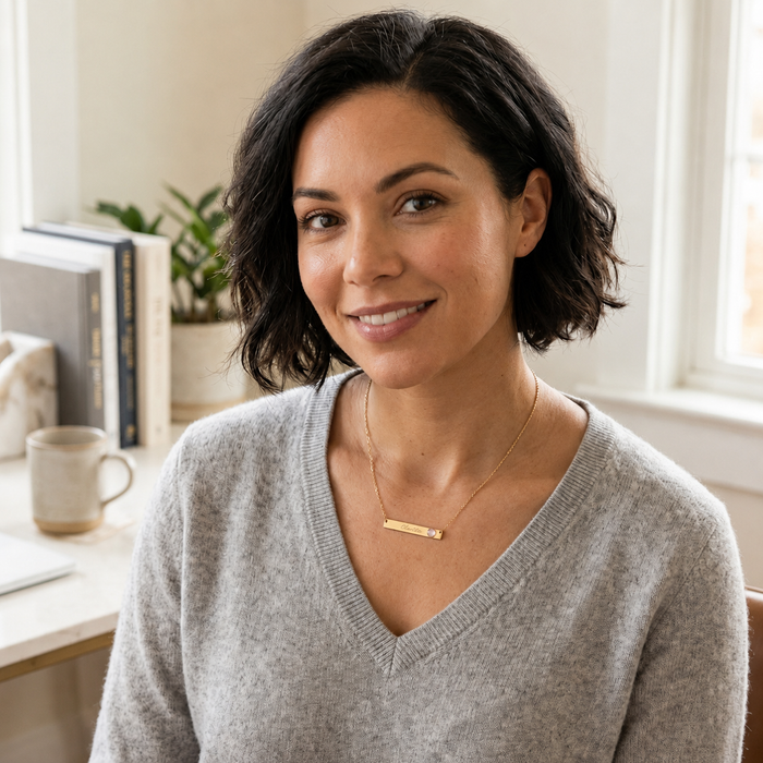 Woman wearing dainty personalized engraved bar necklace with April birthstone