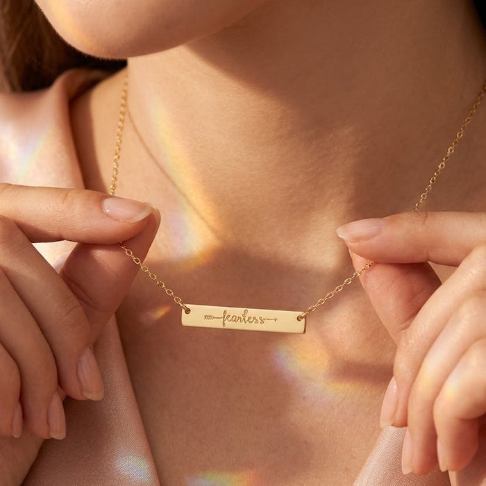 Personalized engraved bar necklace in yellow gold filled worn on woman
Custom horizontal bar necklace engraved with meaningful word in yellow gold
