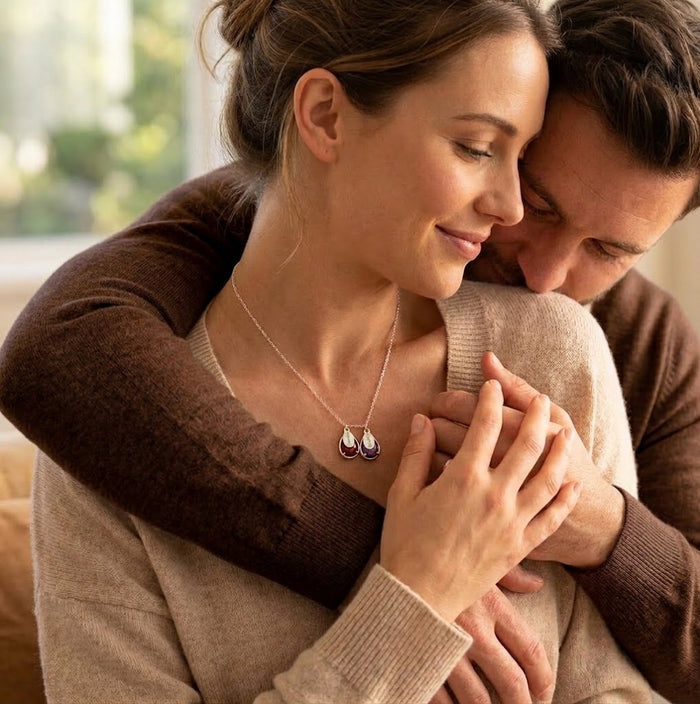 Mother wearing personalized family birthstone necklace while holding child