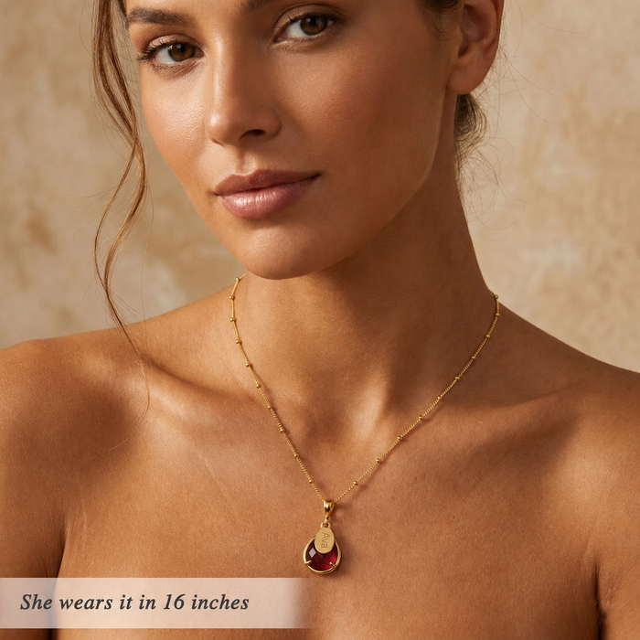 Gold garnet name necklace worn by a model with 16 inch chain length.