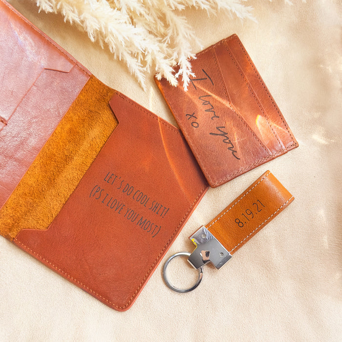 passport, card holder and large leather keychain on beige background. Full leather collection also includes several keychain styles like paddle and loop, luggage tags, passport holders, card and wallet holders, leather anniversary, jet setter, graduation gift, gift for him, gift for her, leather gift, travel accessories, graduation gift, grad gift, mothers day gift, christmas gift, valentines day gift