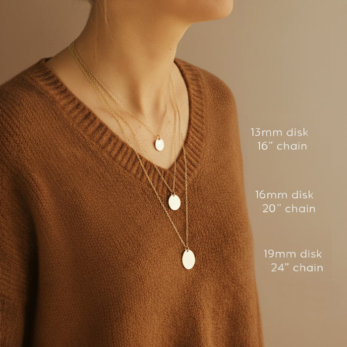 Model wearing layered gold disc pendant necklaces in three sizes with chain length guide text (13mm on 16" chain, 16mm on 20" chain, 19mm on 24" chain); sizing reference image for custom engraved name or monogram disc necklace, dainty minimalist jewelry for everyday wear.
