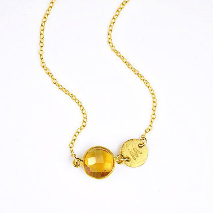 Single gold filled citrine birthstone november birthstone jewelry necklace with brushed initial disk on a white background.