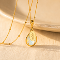 Personalized opalite October birthstone necklace with engraved name charm on gold satellite chain.