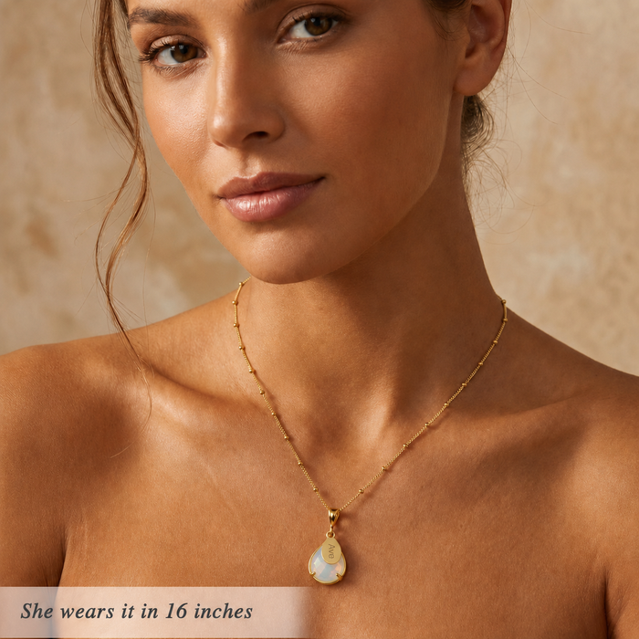 Gold opalite name necklace worn by a model with 16 inch chain length.