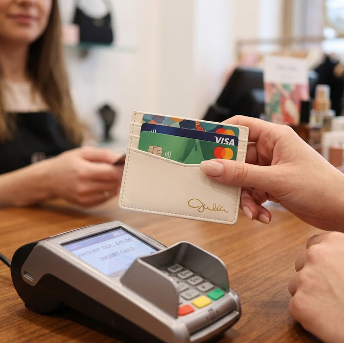 Person using a custom engraved PU leather card holder at a payment terminal, showing slim wallet design for credit cards.