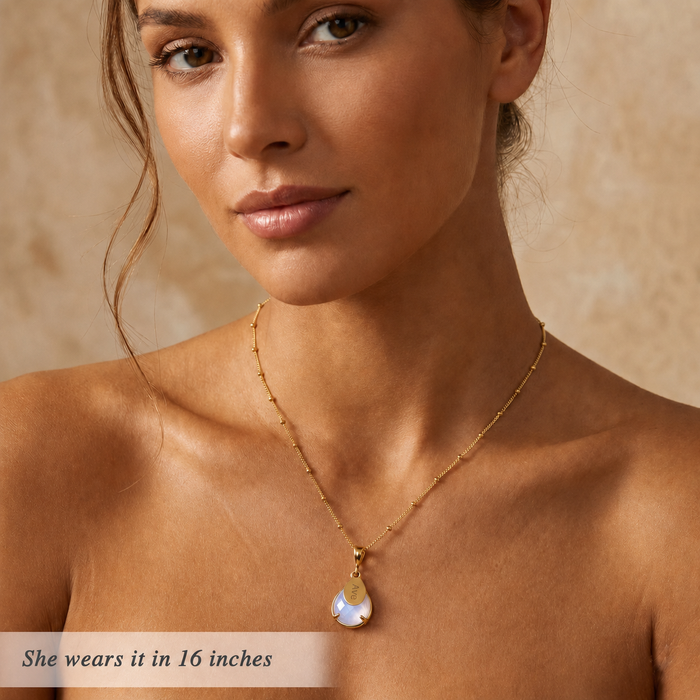 Model wearing personalized rainbow moonstone name necklace, showing dainty June birthstone pendant scale on a 16 inch chain.
