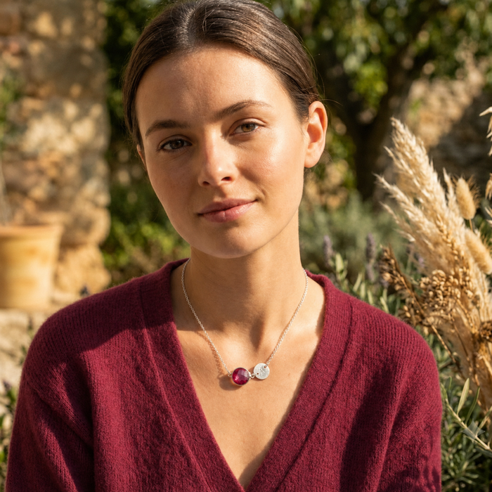Model wearing a personalized ruby initial necklace outdoors in warm natural light