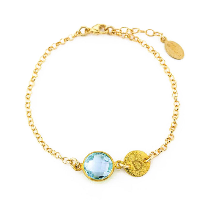 Custom gold filled blue topaz birthstone bracelet with brushed hand stamped initial disk on a white background. december birthstone bracelet, initial bracelet.