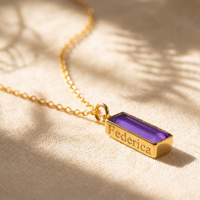 Purple amethyst bar necklace with hidden engraving on gold pendant in warm sunlight.