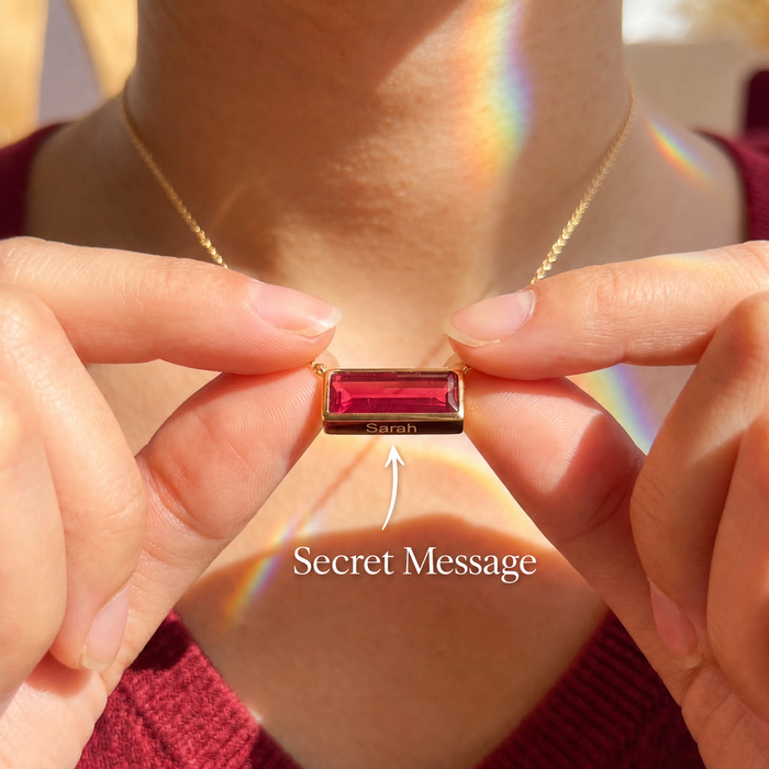 Ruby bar necklace with secret message engraving shown on model in warm sunlight.