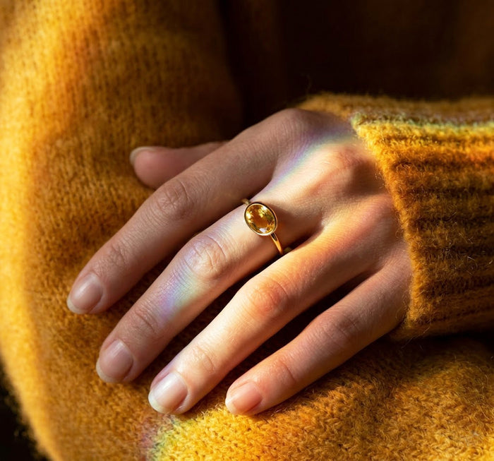 Elegant model wearing a gold citrine ring and small gold earrings, styled with warm light and a cozy sweater, perfect for showing this minimalist November birthstone ring as an everyday gift for her.