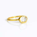a gold clear quartz ring shown on white background. stackable. Stacking rings, bezel set, small oval, dainty oval, birthstone rings, sterling silver stamp, birthstone ring, birthstone jewelry, clear gemstone, clear quartz birthstone, april birthstone, april gemstone,  stack set, stacking rings, christmas gift, birthstone ring, mother's day gift for her, gift for mom, gift for fiance, gift for girlfriend, wedding jewelry, bridesmaid jewelry, anniversary jewelry, anniversary gift, birthday gift