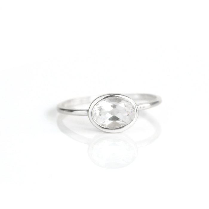 a sterling silver clear quartz ring shown on white background. stackable. Stacking rings, bezel set, small oval, dainty oval, birthstone rings, sterling silver stamp, birthstone ring, birthstone jewelry, clear gemstone, clear quartz birthstone, april birthstone, april gemstone,  stack set, stacking rings, christmas gift, birthstone ring, mother's day gift for her, gift for mom, gift for fiance, gift for girlfriend, wedding jewelry, bridesmaid jewelry, anniversary jewelry, anniversary gift, birthday gift