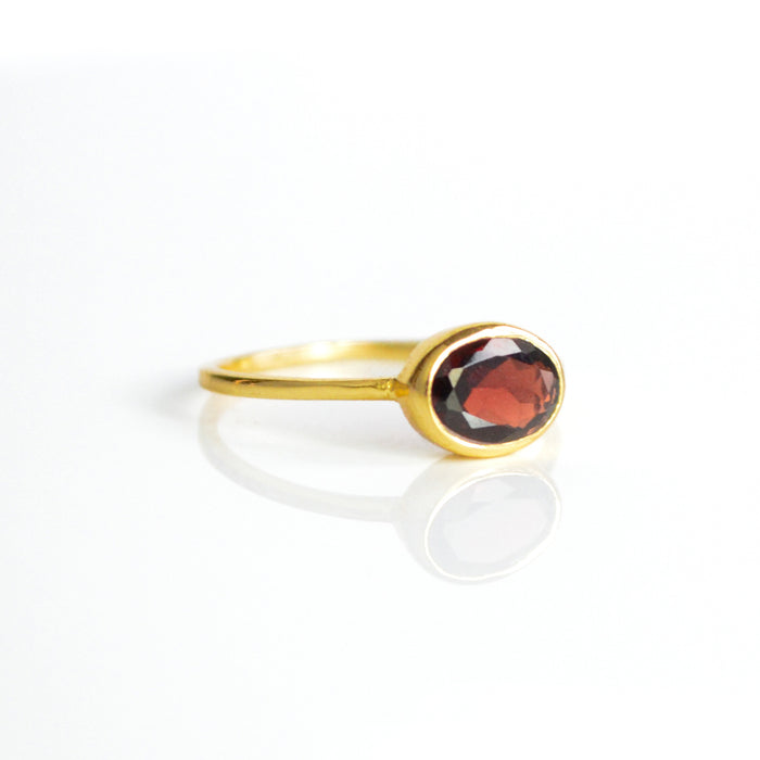 a gold garnet ring shown on white background. stackable! Stacking rings, bezel set, birthstone jewelry, red gemstone, red birthstone, january birthstone, january gemstone, stack set, stacking rings, gemstone ring, birthstone ring, mother's day gift for her, gift for mom, gift for fiance, gift for girlfriend, wedding jewelry, bridesmaid jewelry, anniversary jewelry, anniversary gift, birthday gift, christmas gift, valentine's day gift, valentine's day rings, dainty ring, cocktail ring, statement ring
