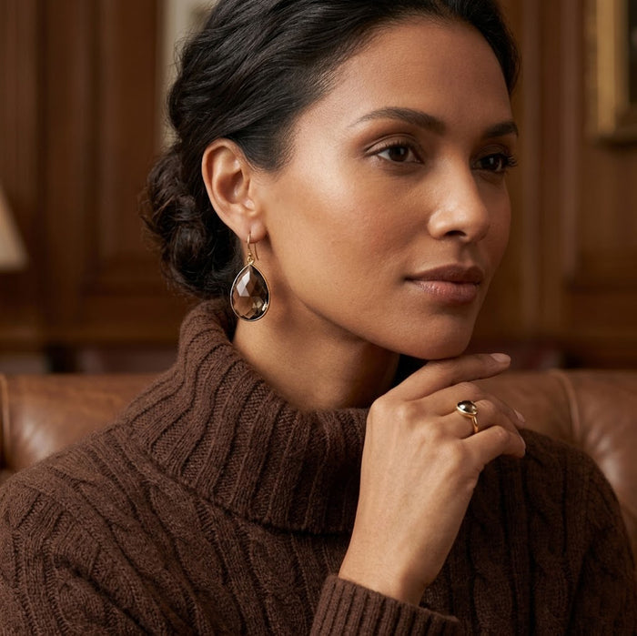 Model wearing smoky quartz earrings with warm brown gemstone and gold setting