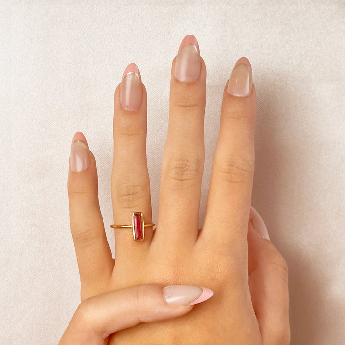 Ruby quartz birthstone ring worn on hand with clean neutral background.