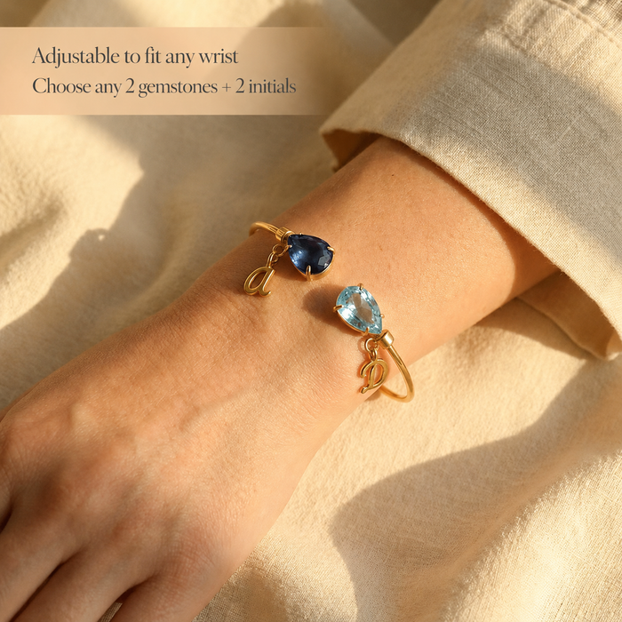 Custom two birthstone bangle bracelet worn on wrist with initials, a meaningful gift for mom, daughter, sister, or best friend.