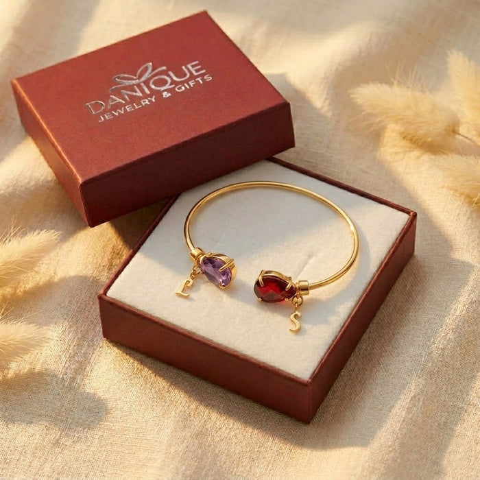 Gift-ready two birthstone initial bangle bracelet displayed in Danique Jewelry box with colorful gemstones and letter charms.