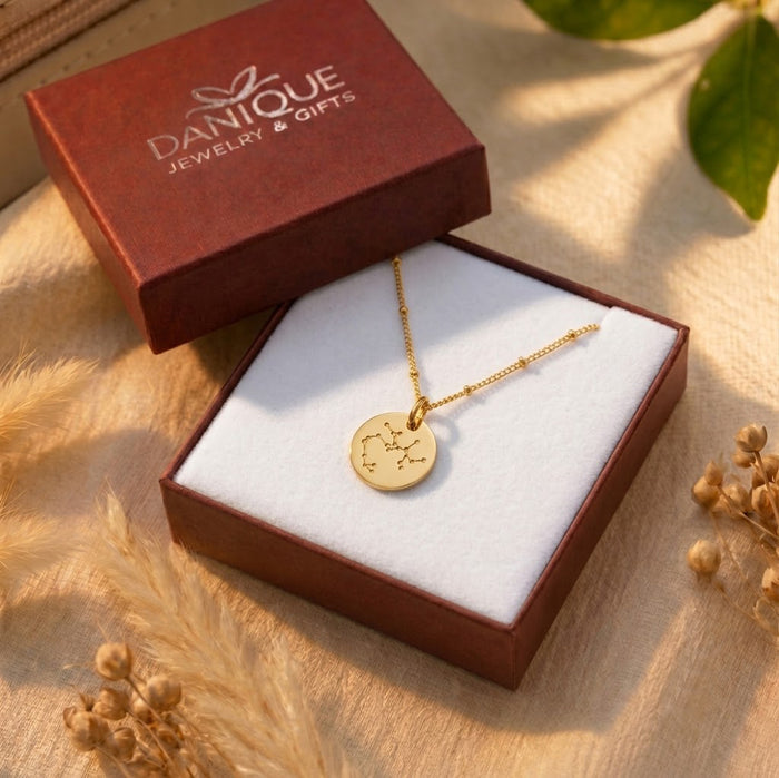 Gift-ready zodiac constellation necklace displayed in a Danique Jewelry box with warm floral styling.